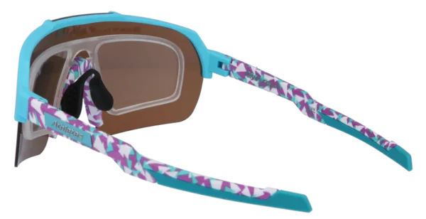 Turquoise protective sport goggles with brown lenses and purple-teal patterned temples, suitable for swimming or training.
