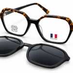 Two pairs of eyewear on a white background: tortoise-shell frame reading glasses and black sunglasses with dark lenses