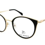 Gold and black round eyeglasses by Eva Minge with clear nose pads (angled view).