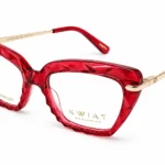 Red translucent eyeglasses with diamond-cut frames and gold-tone temples; bold fashion eyewear