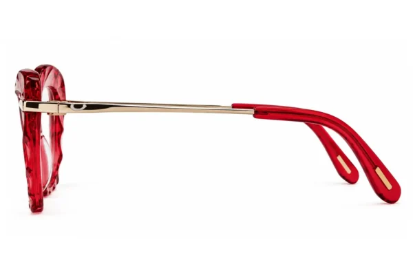 Side view of red translucent sunglasses with gold-tone temples laid on a white background